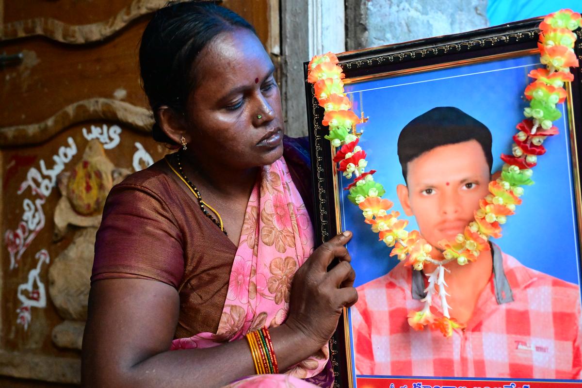 Gundala Nagendramma holding a photo of her son, Gundala Anjaneyulu, who died by suicide on August 17, 2024, due to crop failure and mounting debts, at Telukutla village in Gurazala mandal of Palnadu district.
