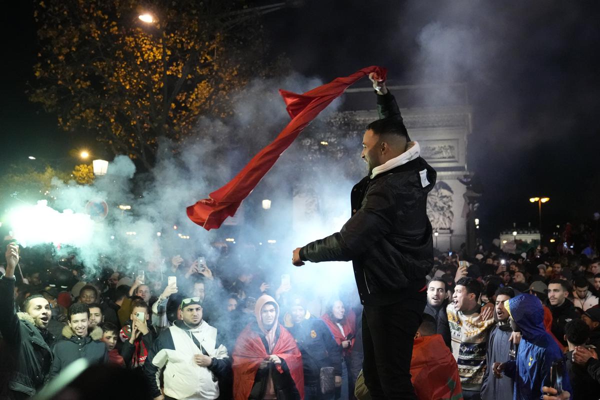 Morocco fans celebrate their team’s victory on the Champs-Elysees avenue in Paris, France, after Morocco and Portugal 
