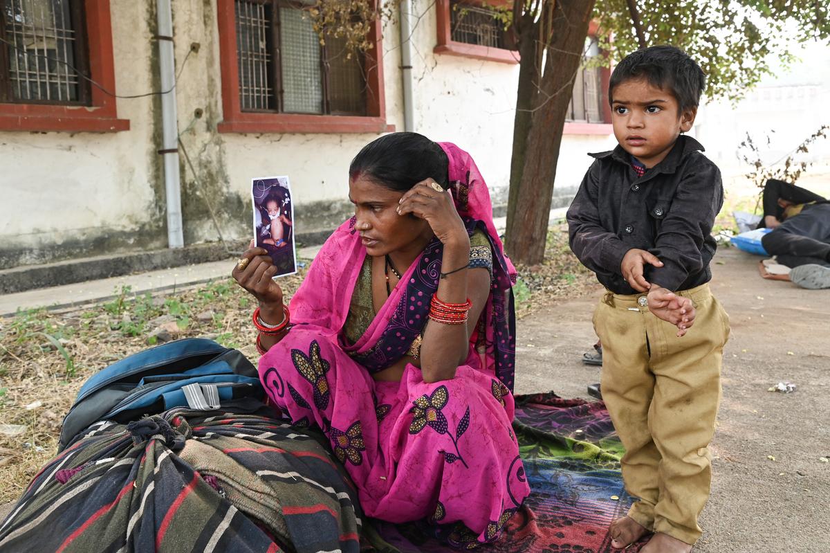 Guddi Devi stares at a photo of her grandson near the hospital’s emergency ward. The infant was rescued from the fire, but passed away on November 17, 2024.