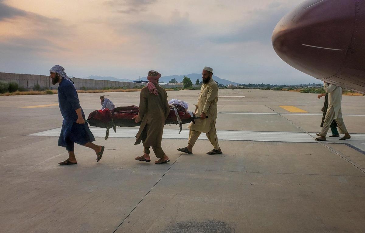 People carry an earthquake victim on a stretcher to an ambulance at an airport in Jalalabad, Afghanistan, on September 1, 2025.
