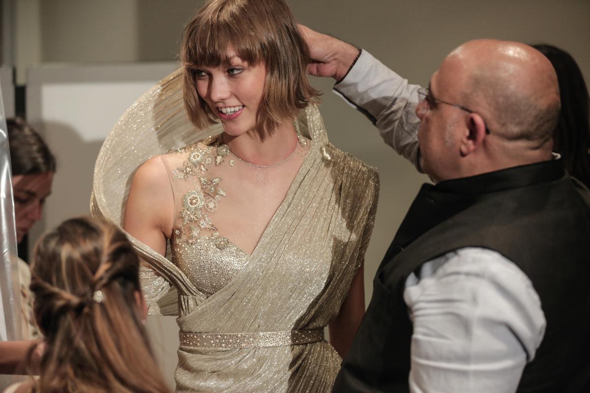Tarun adding the final touches to American supermodel Karlie Kloss’s outfit before the amfAR benefit at Festival de Cannes