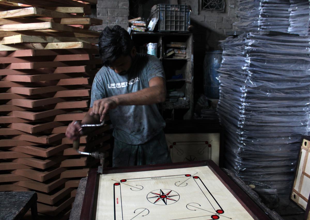 A daily wage worker making carrom boards at a factory in Meerut, Uttar Pradesh.