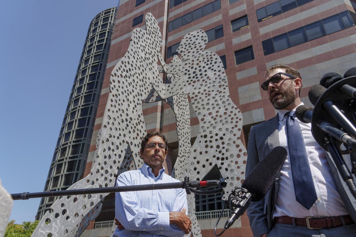 Dr. Mark Chavez, left, a physician from San Diego who is charged in connection with actor Matthew Perry's death from an accidental ketamine overdose, listens as his attorney Matthew Binninger talks to the media at the Roybal Federal Courthouse in Los Angeles, Friday, Aug. 30, 2024. (AP Photo/Damian Dovarganes)