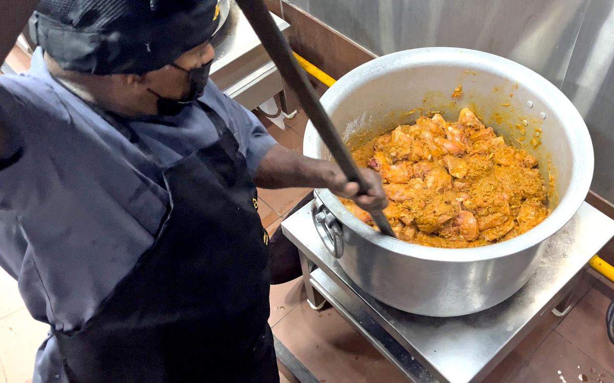 A cook mixes spices and chicken pieces in the central kitchen of Azad Hotel in Thiruvananthapuram. 