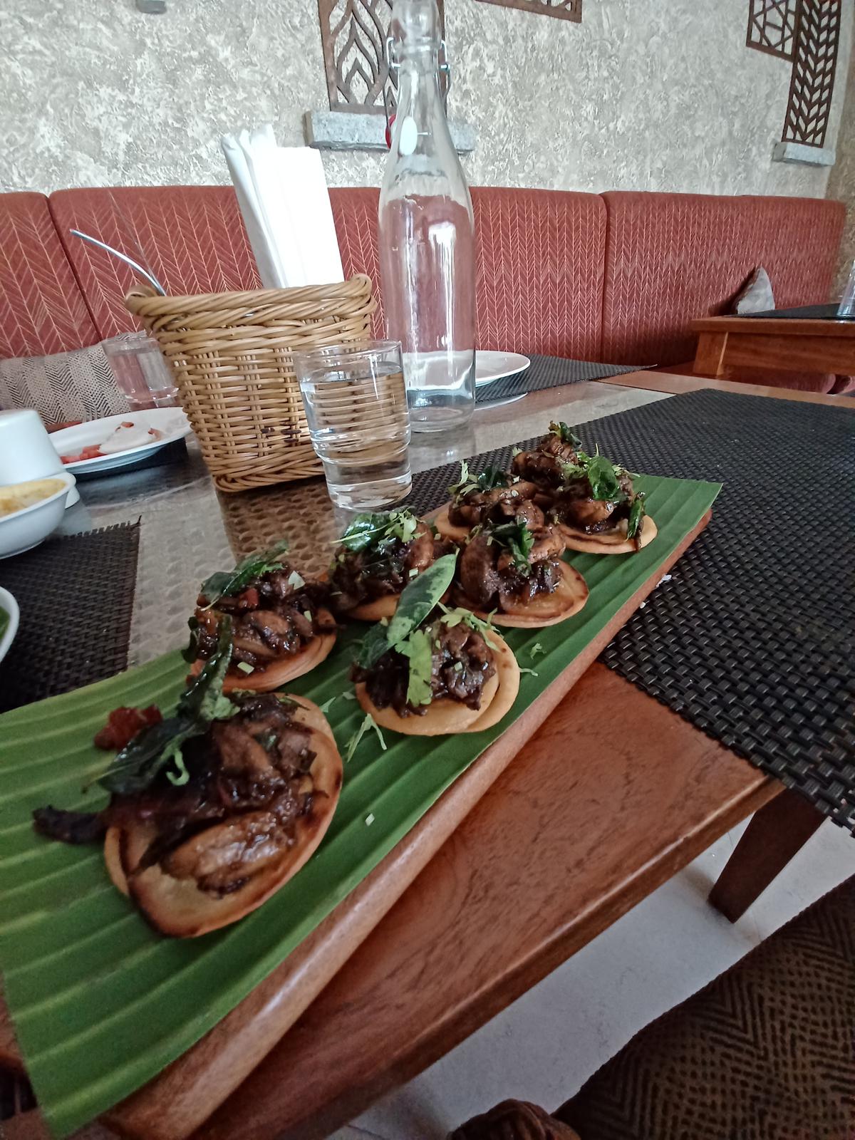 Deep-fried coin parottas topped with Chettinad button mushrooms 