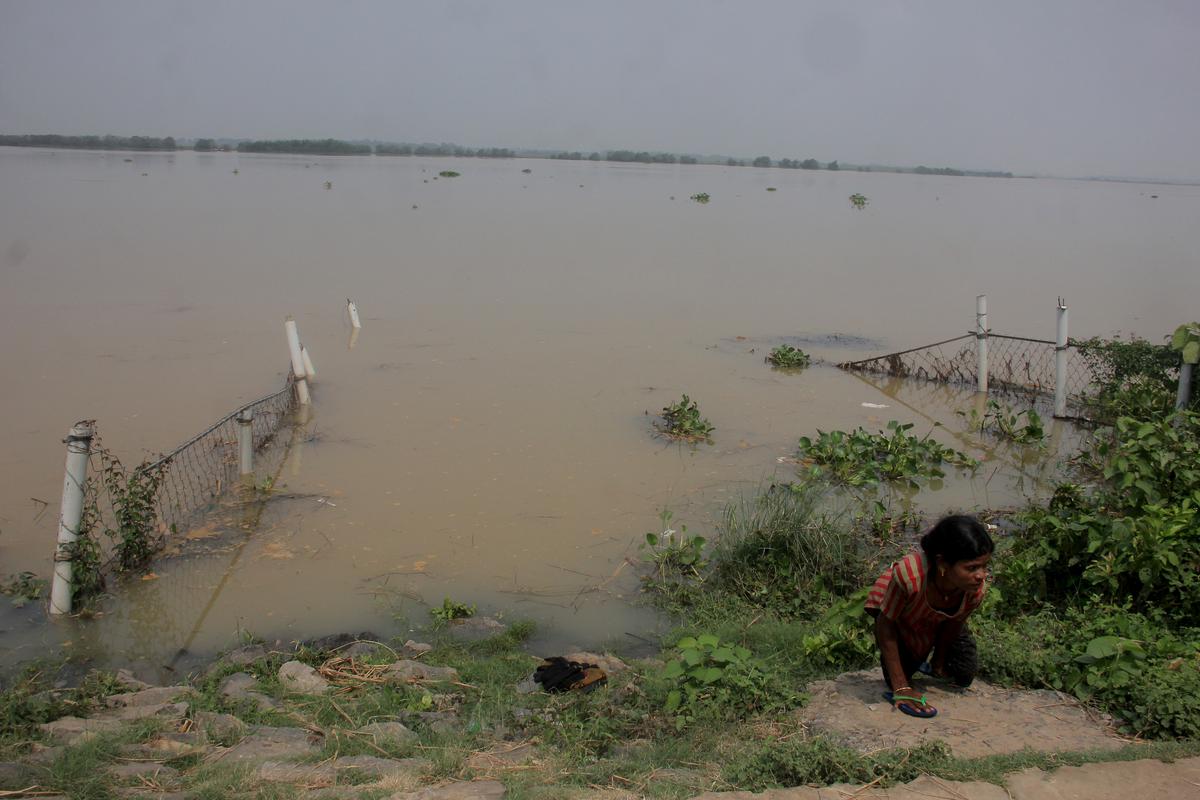 A differently abled woman comes out of a barricaded bathing ghat on the banks of the Brahmani river in Kendrapara district of Odisha.