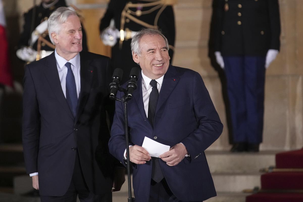 Newly-named Prime Minister François Bayrou, right, and outgoing Prime Minister Michel Barnier smile after the handover at the Prime Minister’s residence in Paris on December 13, 2024. 