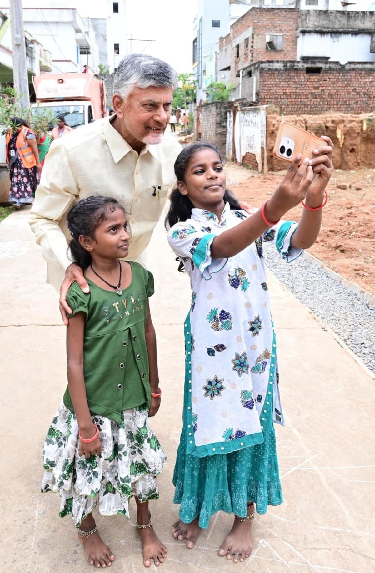 
Chief Minister N. Chandrababu Naidu posing for a selfie photograph with children in a rally on the Swatch Andhra - Swarna Andhra campaign at Peddapuram in Kakinada district on Saturday (August 23).