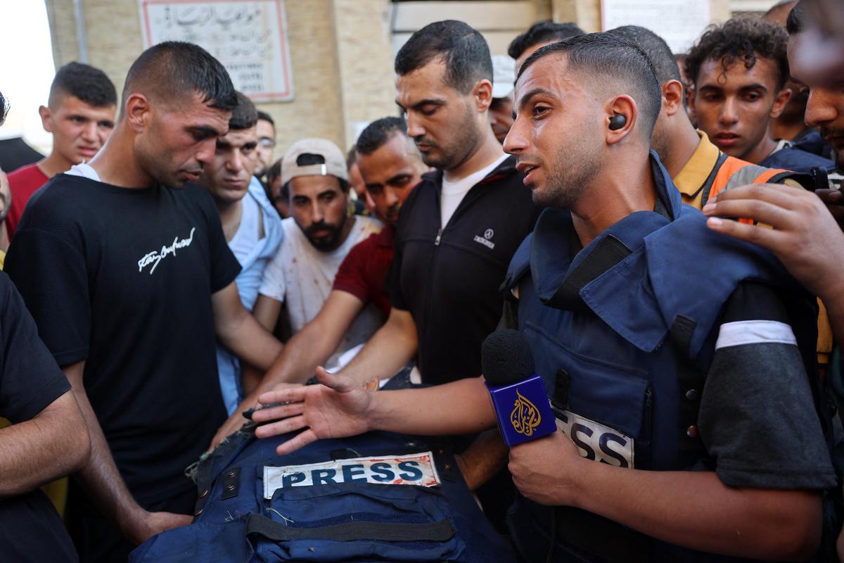 Mourners and colleagues surround the body of Al-Jazeera Arabic journalist Ismail al-Ghoul, killed along with his cameraman Rami al-Refee in an Israeli strike during their coverage of Gaza’s Al-Shati refugee camp, on July 31, 2024. 