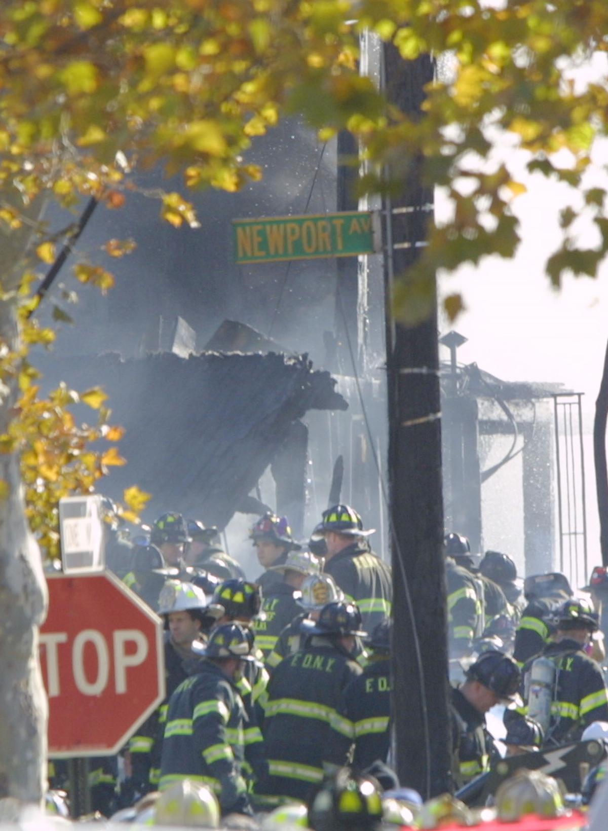 Firefighters work at a burned out residence at the scene of the crash of an American Airlines jetliner en route to the Dominican Republic with 255 people aboard