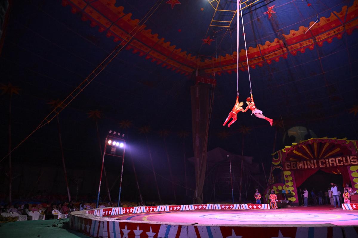  A fine balance of body and mind  while doing stunts from a white cloth that hangs from the ceiling