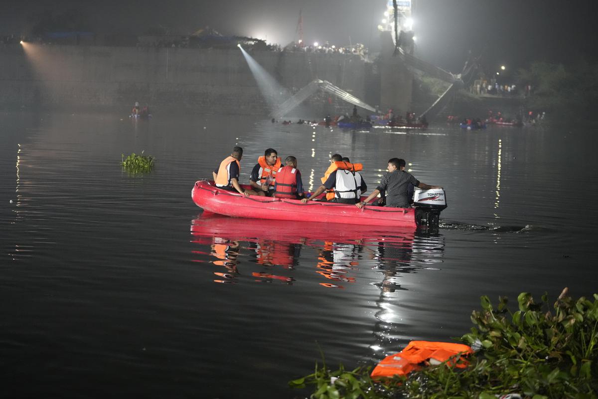 Rescuers on boats search in the Machchu river next to a cable bridge that collapsed in Morbi town in Gujarat on Monday, Oct. 31, 2022.