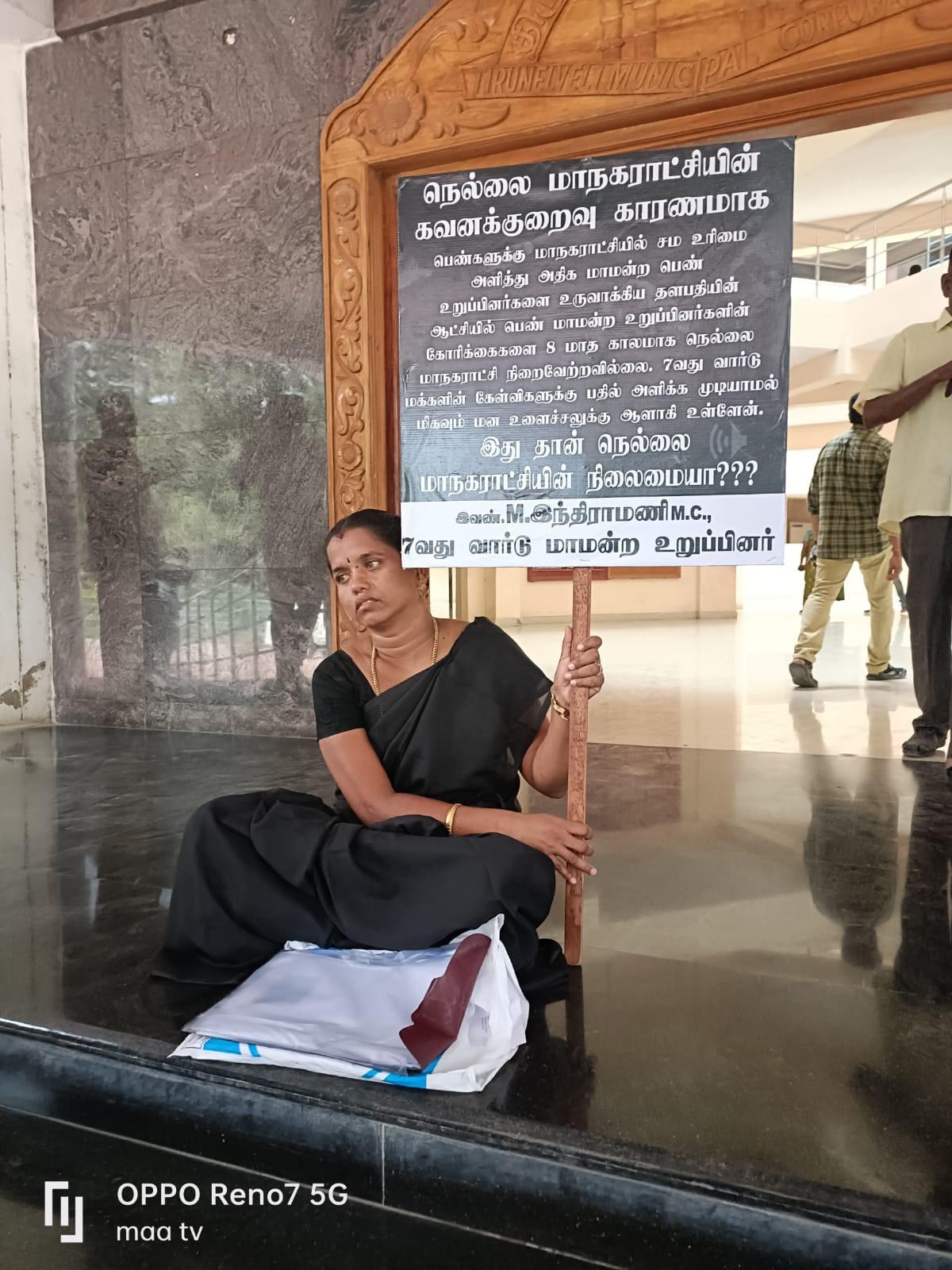 DMK woman councillor sits on the floor in front of Corporation office; stages dharna