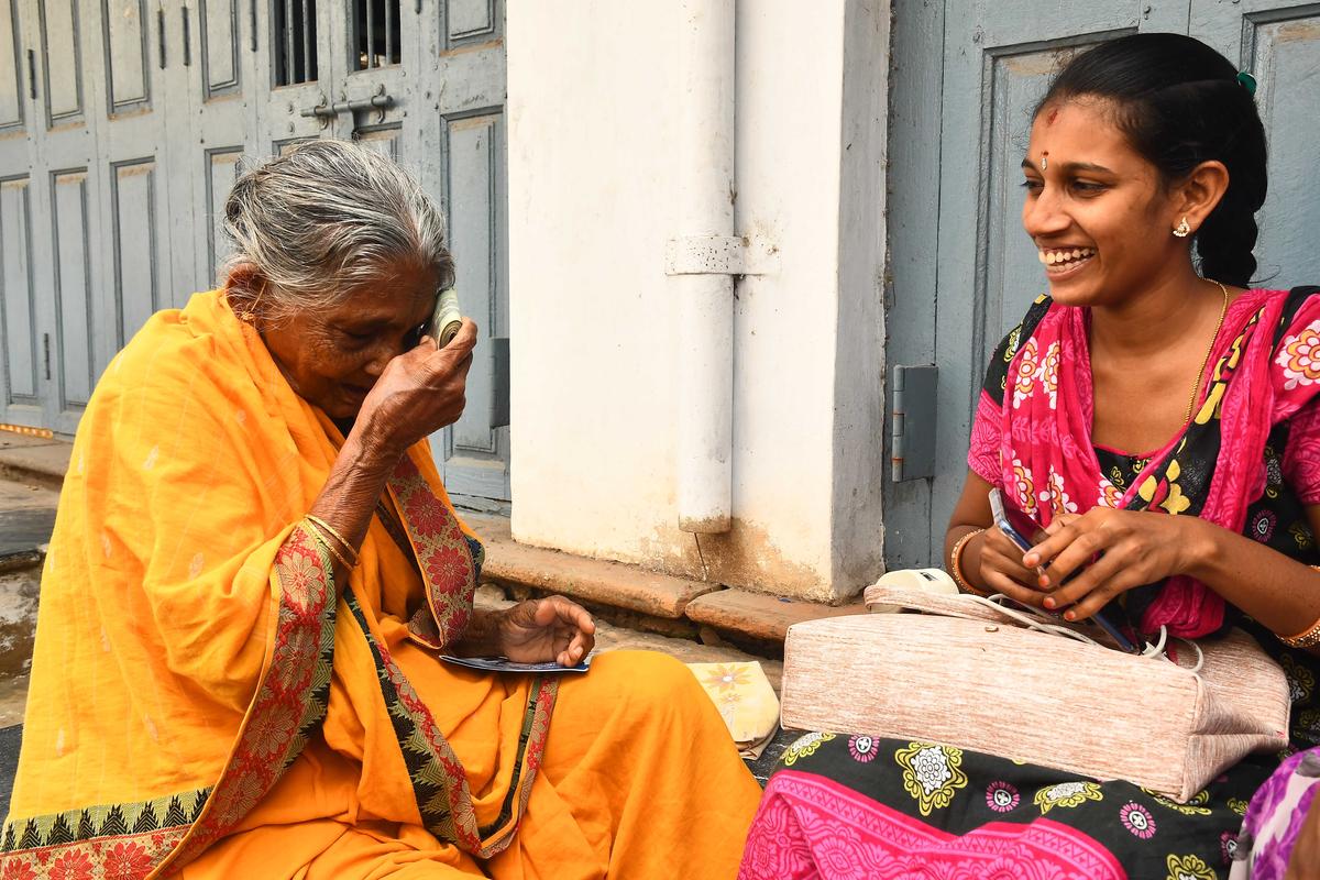 A volunteer handing over pension to a senior citizen at Patamata in Vijayawada. 