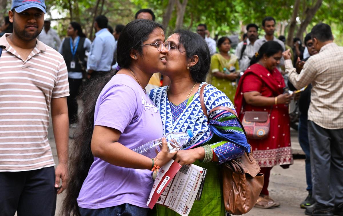 Uma mãe deseja um candidato antes de entrar na sala de exames de um centro durante o NEET UG 2026, na AU College of Engineering, em Visakhapatnam, no domingo.