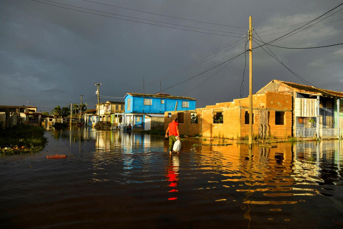 A man walks at a flooded street a day after Hurricane Rafael made landfall in Batabano, Cuba, on November 7, 2024. 