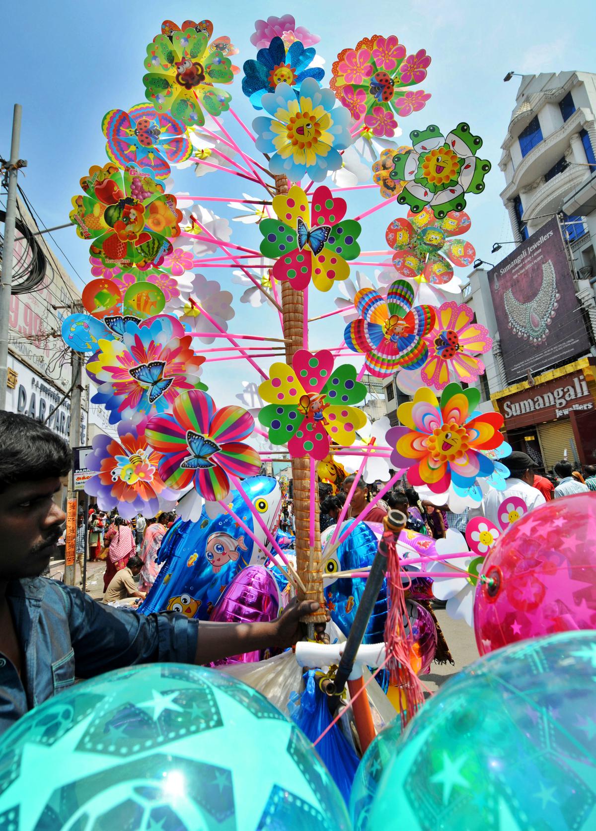 A trader sells hand fans on Raja Street during the festival