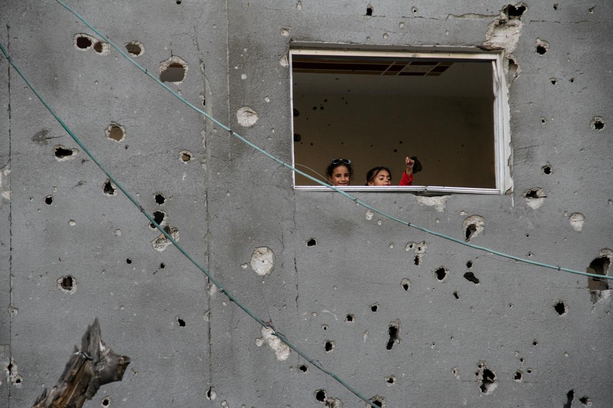 Palestinian children look on from a window during Eid al-Fitr, amid the ongoing conflict between Israel and the Palestinian Islamist group Hamas, in Gaza City on April 11, 2024. 