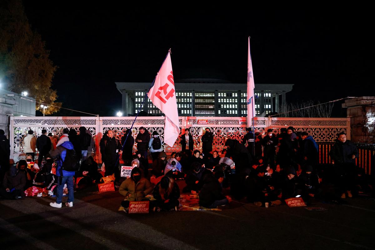 People gather by the gate of the National Assembly, after South Korean President Yoon Suk Yeol declared martial law, in Seoul, South Korea, December 4, 2024. 