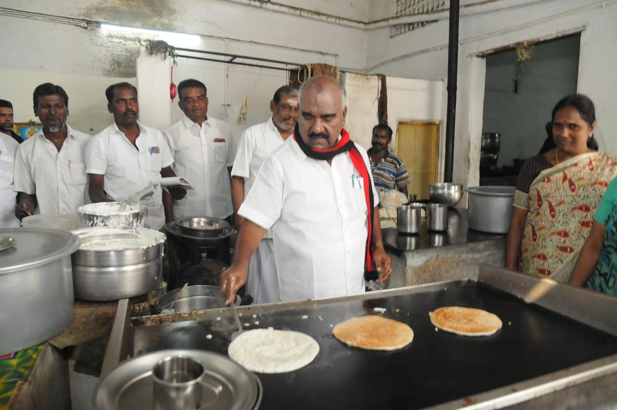 Minister for Minorities Welfare and Welfare for Non-Resident Tamils ​​Gingee KS Mastan preparing dosa at a restaurant while campaigning for the Erode (East) by-election on February 12, 2023.