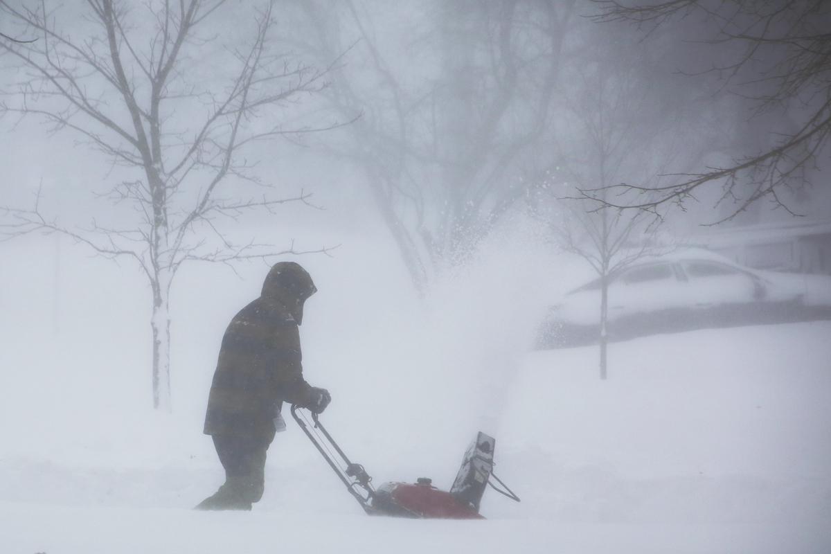 A person clears snow as a winter storm rolls through Western New York on December 24, 2022, in Amherst N.Y. 