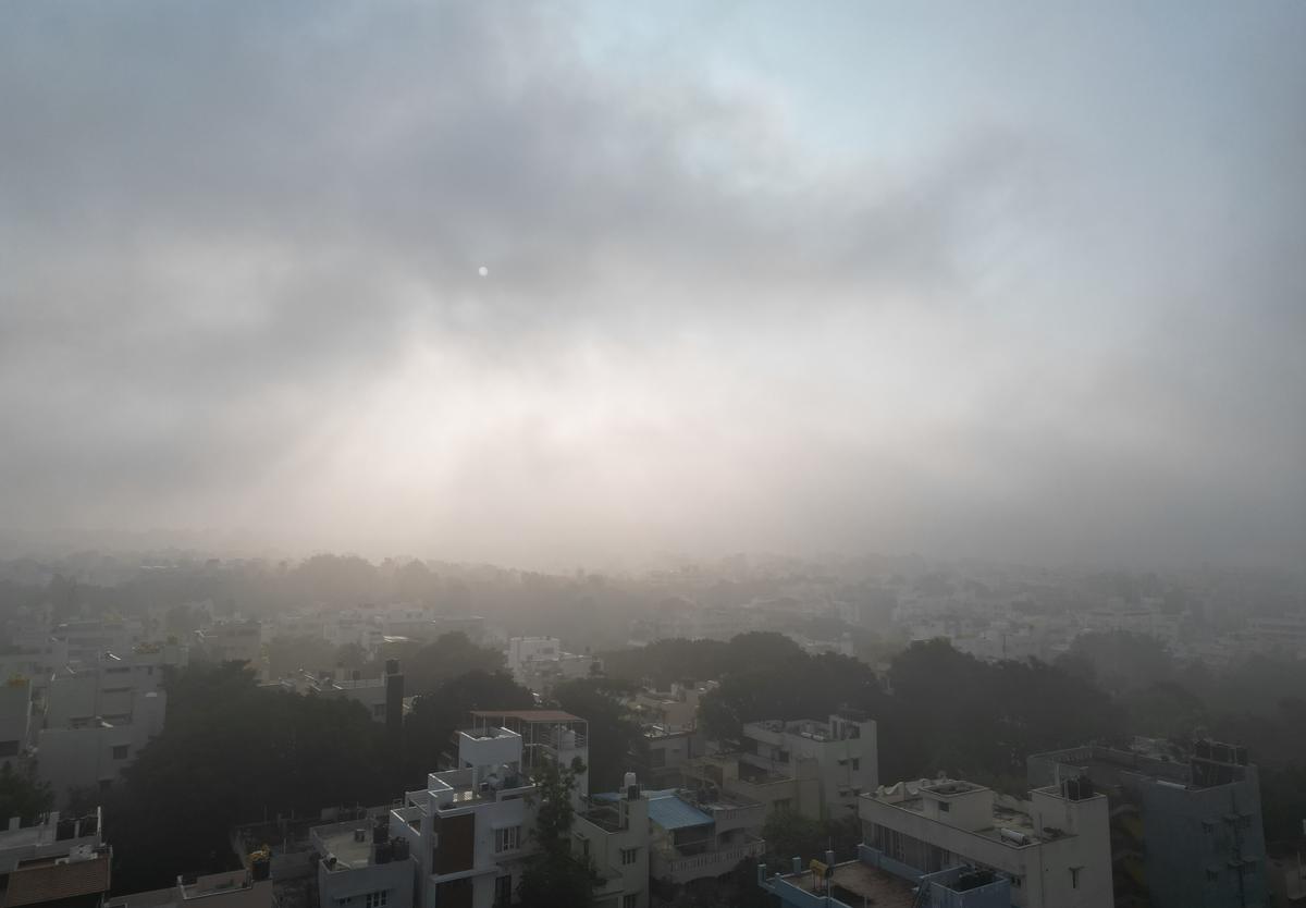 The sun breaks through a foggy blanket across Bengaluru on Sunday. 