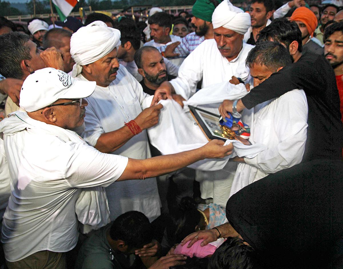 Farmer leader Naresh Tikait taking away the medals from protesting wrestlers.