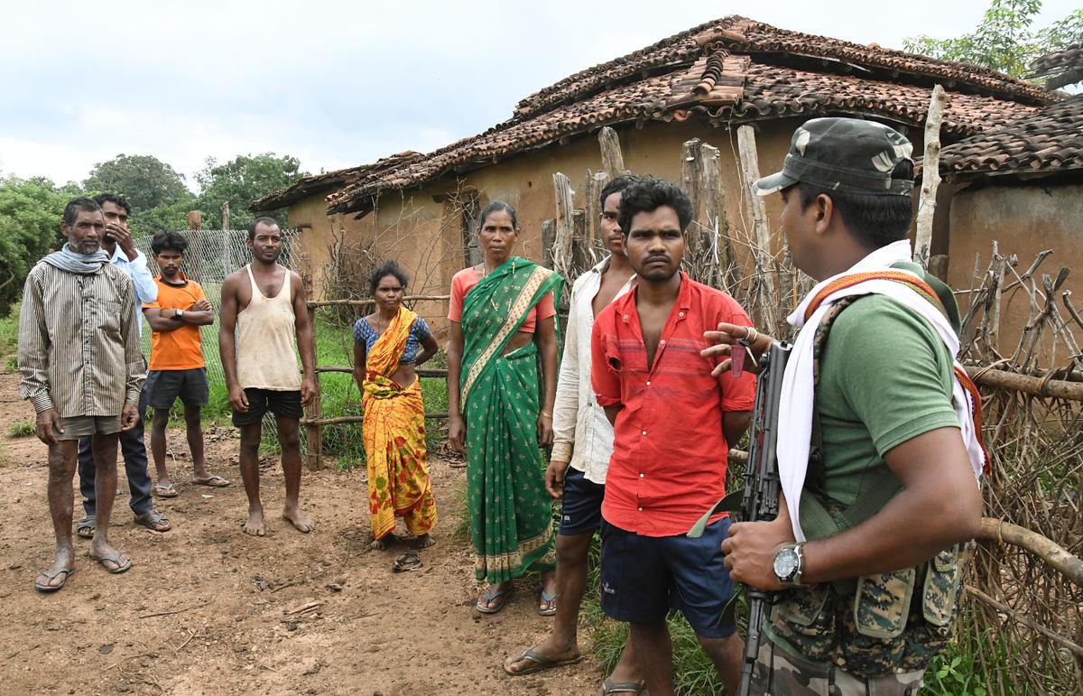 Residents of Hatedih village interact with a police officer. 