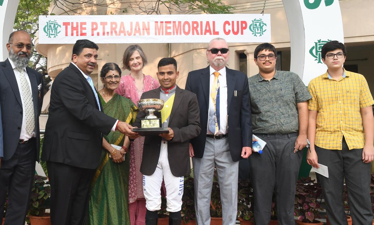 Rewarding a champion: The Tamil Nadu State Finance Minister Palanivel Thiaga Rajan presenting the P.T. Rajan Memorial Cup to Empress Eternal’s jockey Farid Ansari in the presence of his family members, trainer R. Foley and M.A.M.R. Muthiah. at the Madras Race Club on Saturday, January 21.
