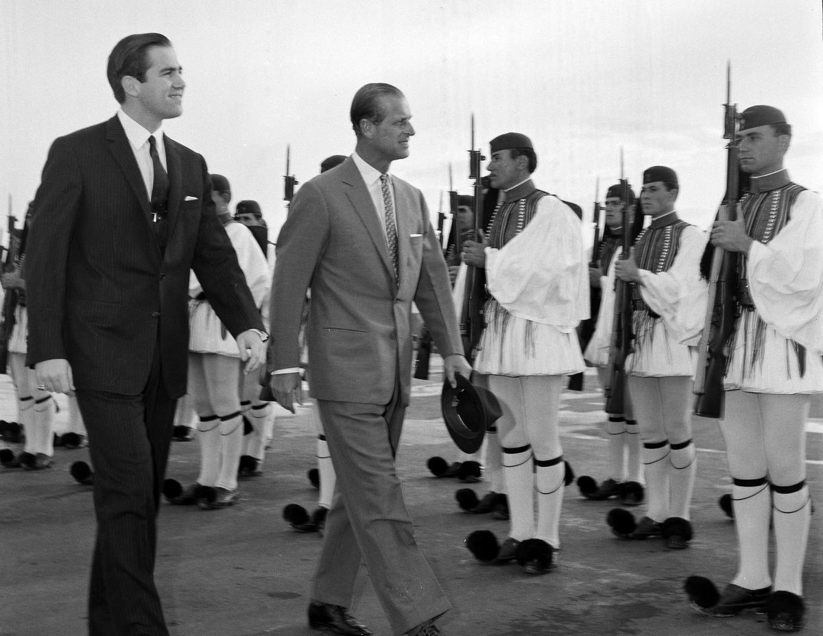 In this March 25, 1965 file photo, Greece's King Constantine II, left, and Britain's Prince Philip review an honor guard of the Greek Royal Evzon Guard, as the prince arrives in Athens for a brief visit as the Greek's guest arrives at the airport.  royal family.  Constantine, the former and last king of Greece, has passed away. 