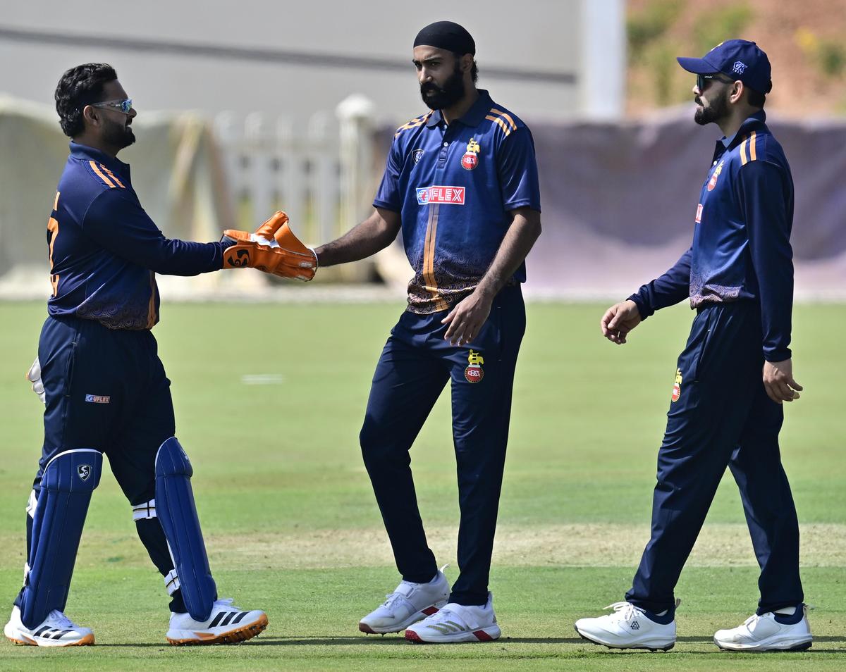 Delhi's Simarjeet celebrates with Pant and Kohli.