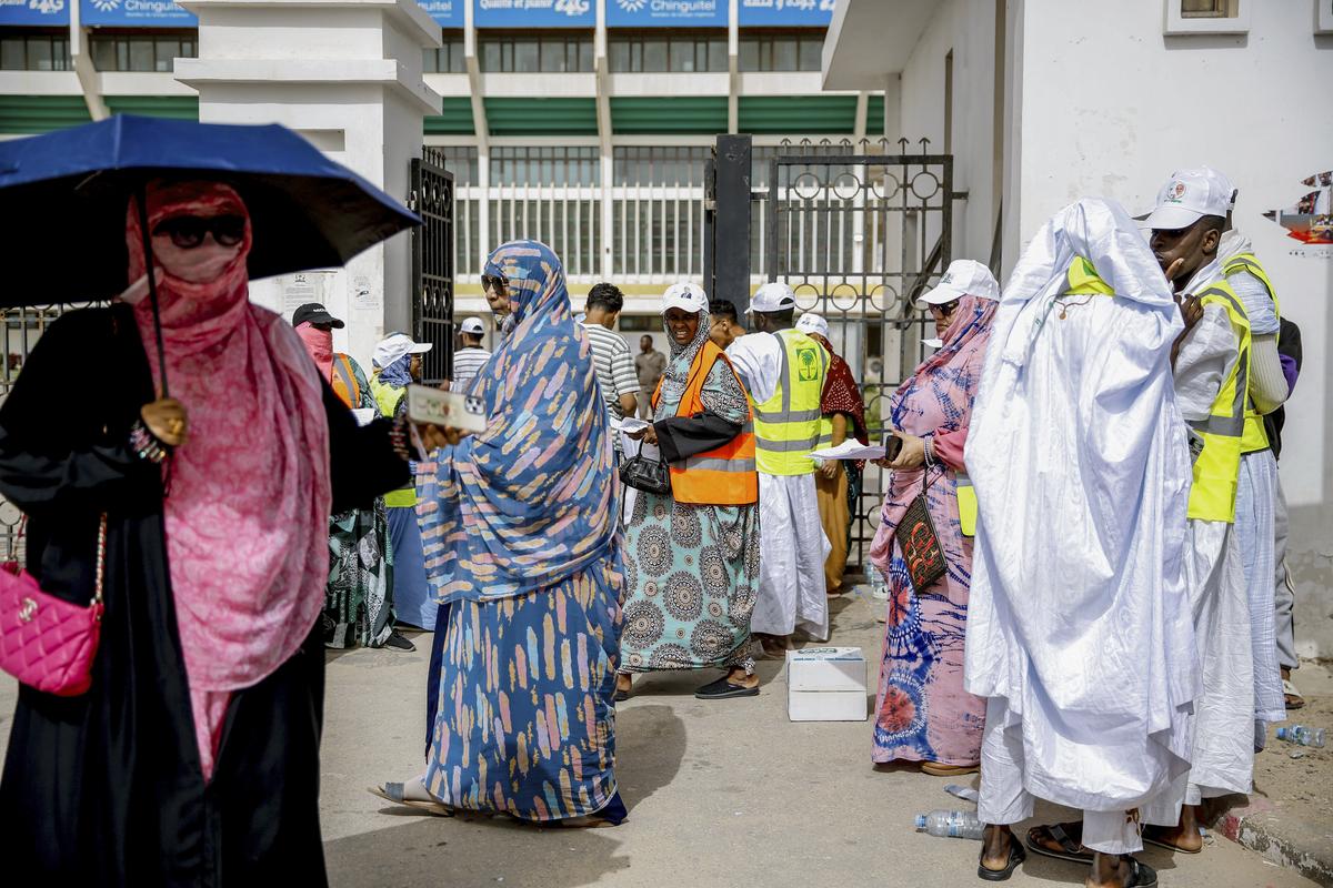 People wait outside a polling station to vote , during the presidential election, in Nouakchott, Mauritania, Saturday, June 29, 2024.  