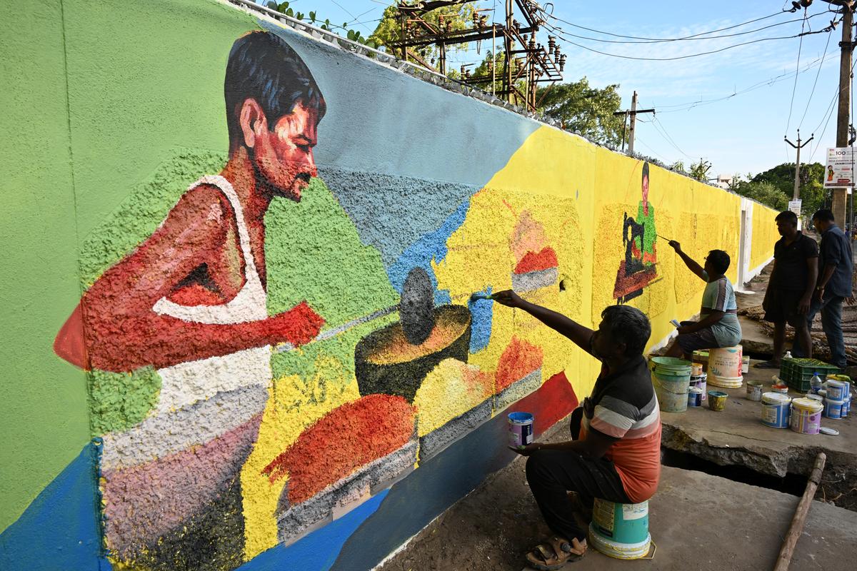 Paintings being done on a wall of Madurai city on Friday. 