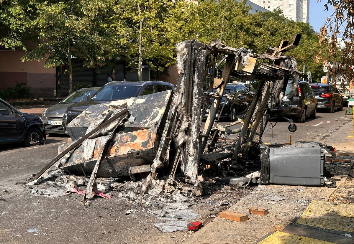 28 जून को फ्रांस के पेरिस उपनगर नैनटेरे में यातायात रोकने के दौरान एक फ्रांसीसी पुलिस अधिकारी द्वारा मारे गए 17 वर्षीय किशोर की मौत के अगले दिन युवाओं और पुलिस के बीच झड़प के दौरान जली हुई एक इमारत सड़क पर देखी गई। , 2023. 