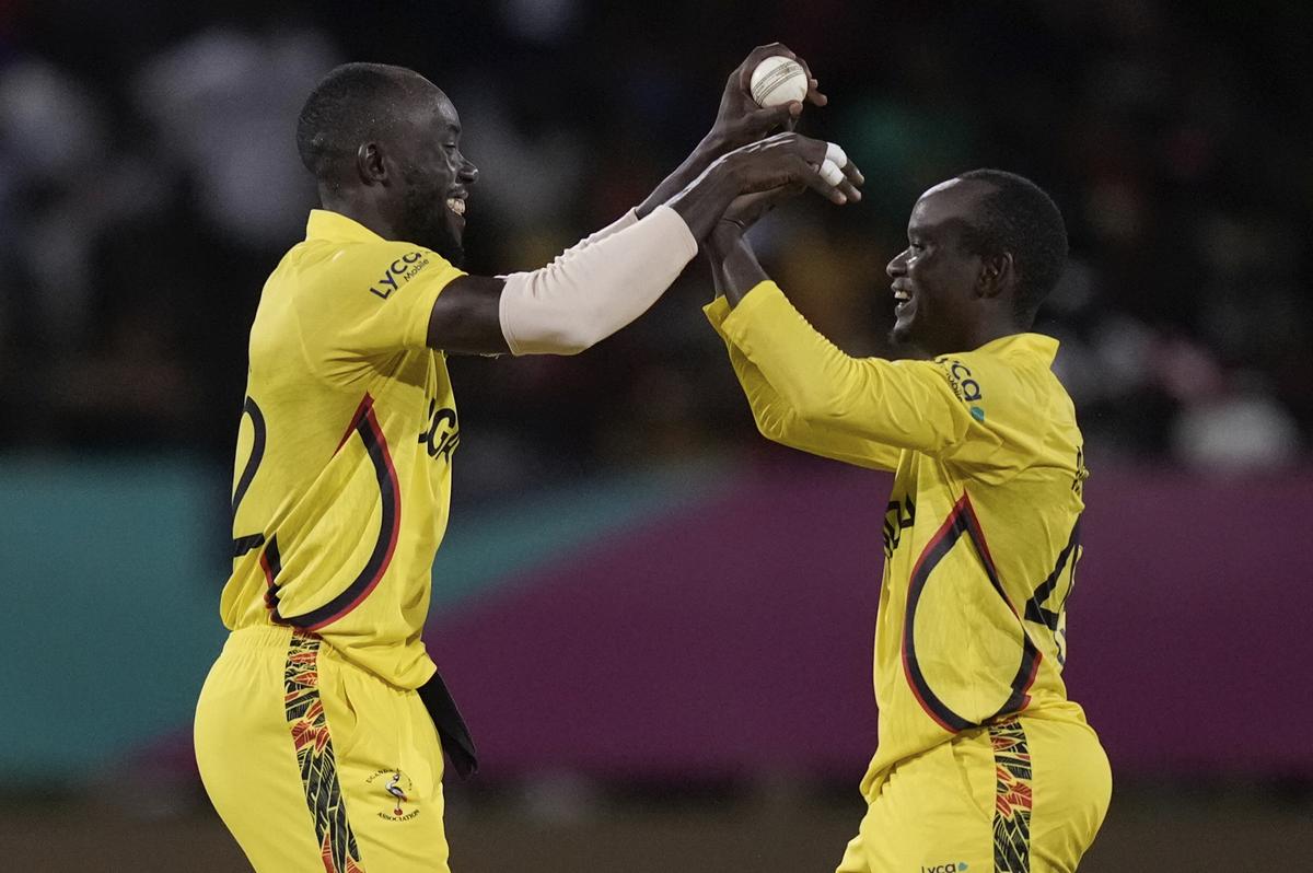 Uganda’s Robinson Obuya, left, and captain Brian Masaba celebrates after Obuya took the catch to dismiss West Indies’ captain Rovman Powell for 23 runs during an ICC Men’s T20 World Cup cricket match at Guyana National Stadium in Providence, Guyana on June 8, 2024. 