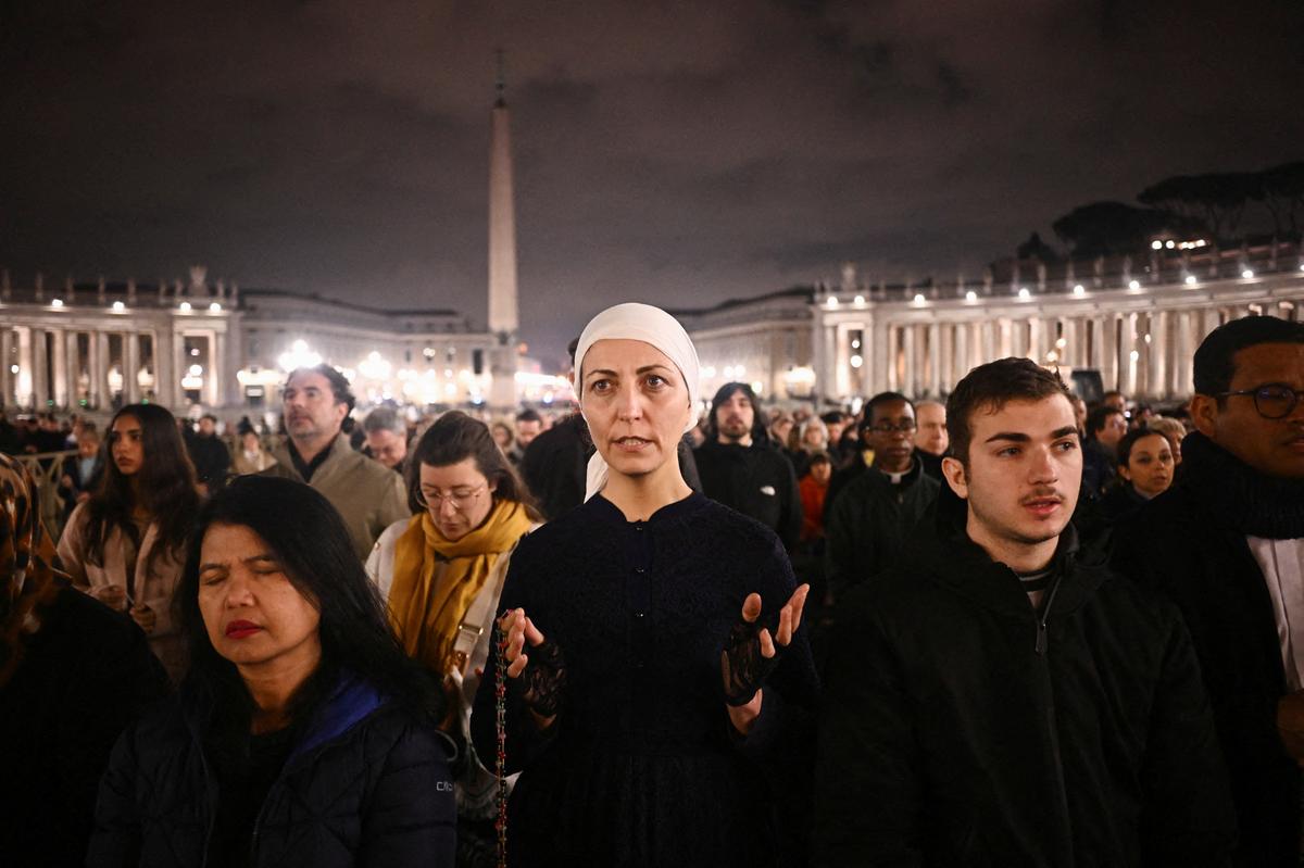People take part in a prayer service at St. Peter’s Square, as Pope Francis continues his hospitalization, at the Vatican on February 25, 2025.