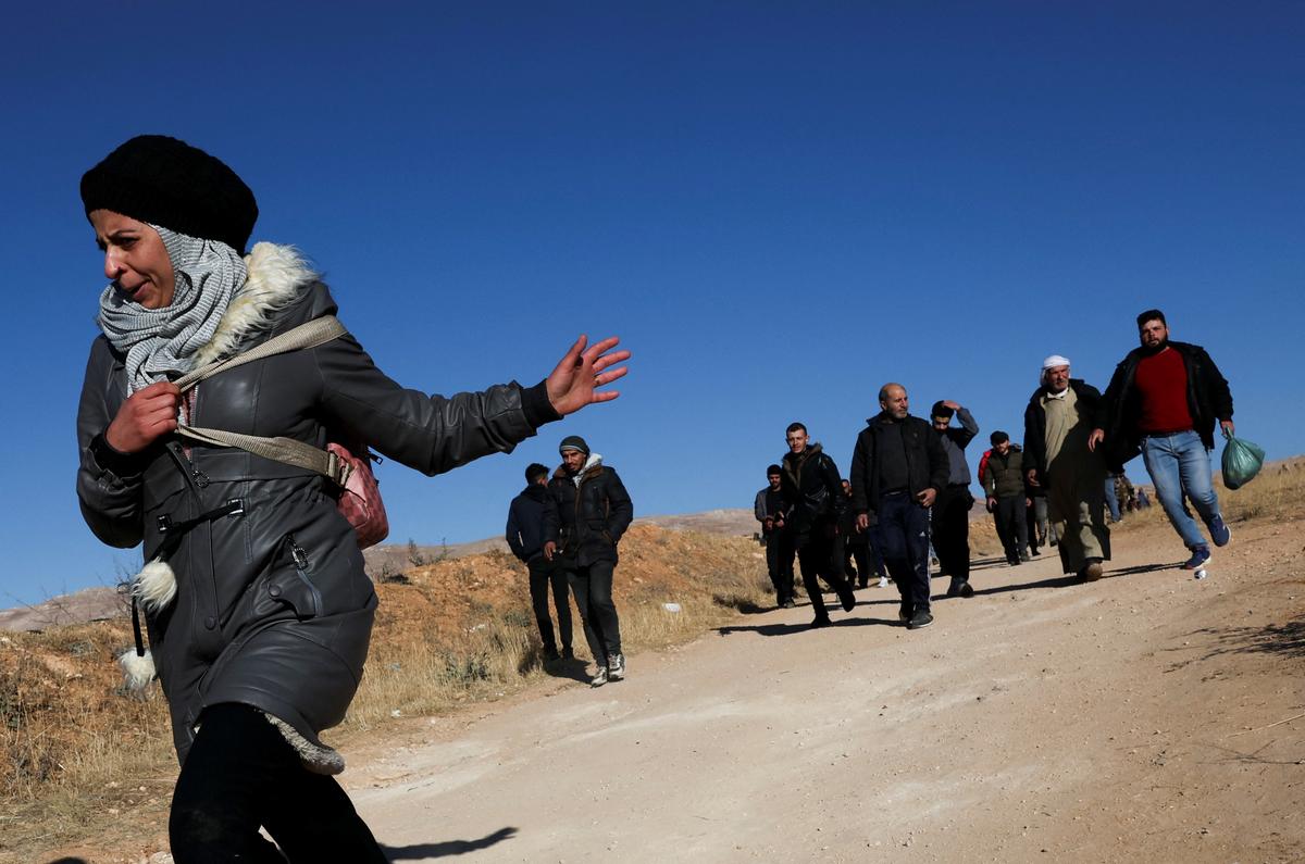 People run towards Sednaya prison as members of the Syrian civil defence group, known as the White Helmets search for prisoners underground in Sednaya, Syria on December 9, 2024.