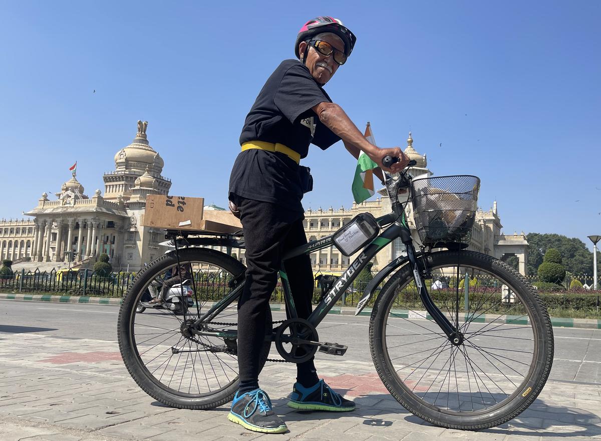 Prof. Kiran Seth stops in front of Vidhana Soudha in Bengaluru during his cycle expedition from Kashmir to Kanyakumari