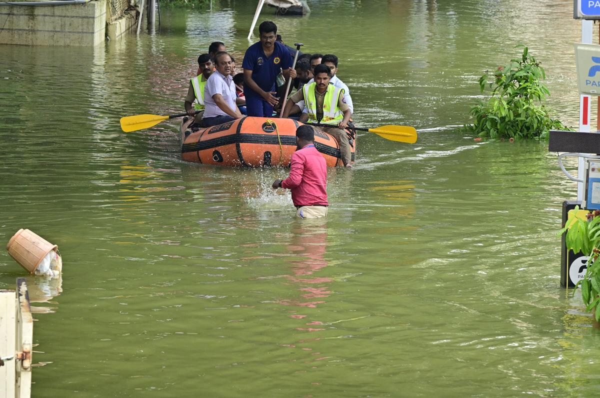 Rescue workers move stranded residents of an apartment in a boat after it was flooded due to heavy rains, at Yelahanka Kendriya Vihar,  in Bengaluru on October 22, 2024. 