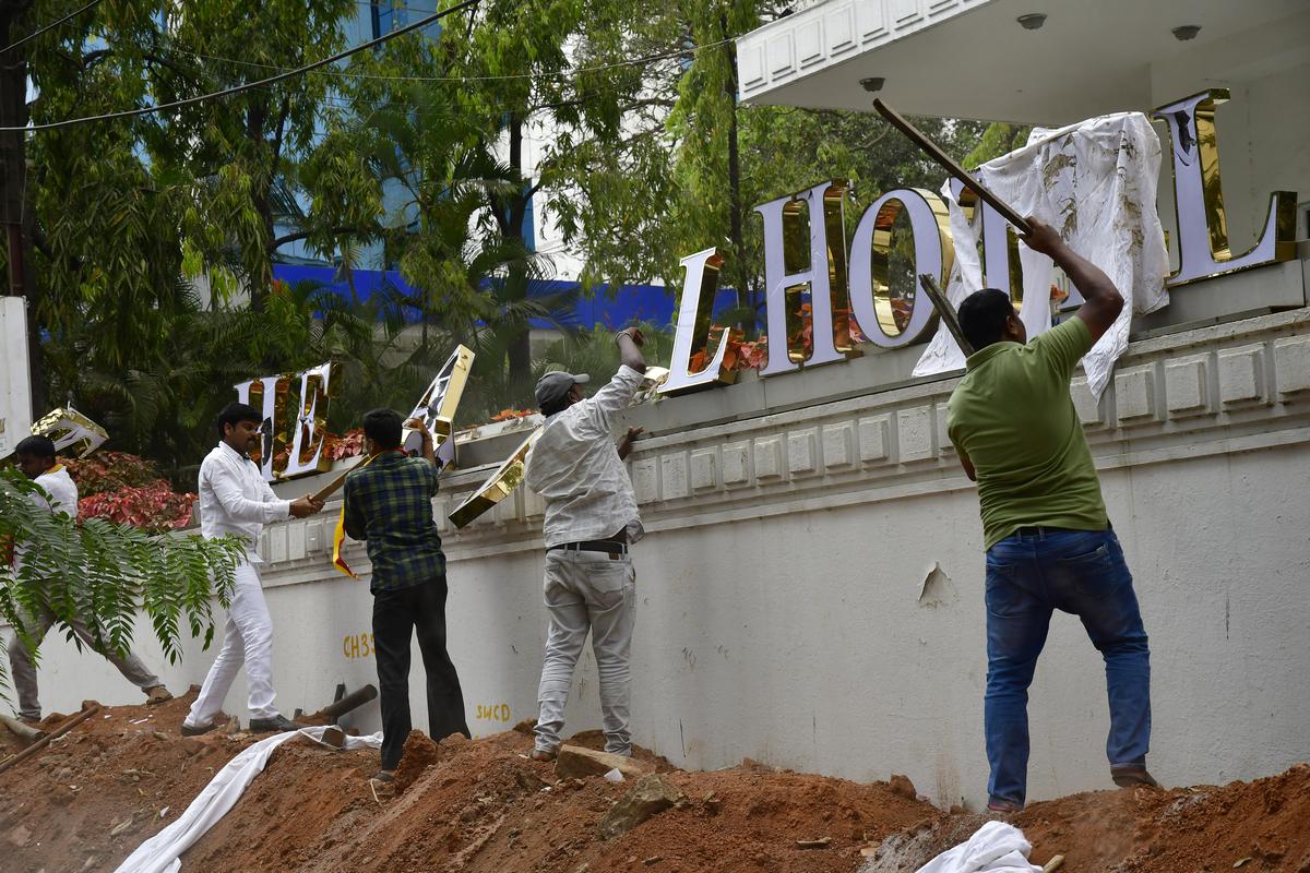 Pro-Kannada activists ransack the English nameboard of a hotel, on Raj Bhavan Road, in Bengaluru on March 8, 2020.  