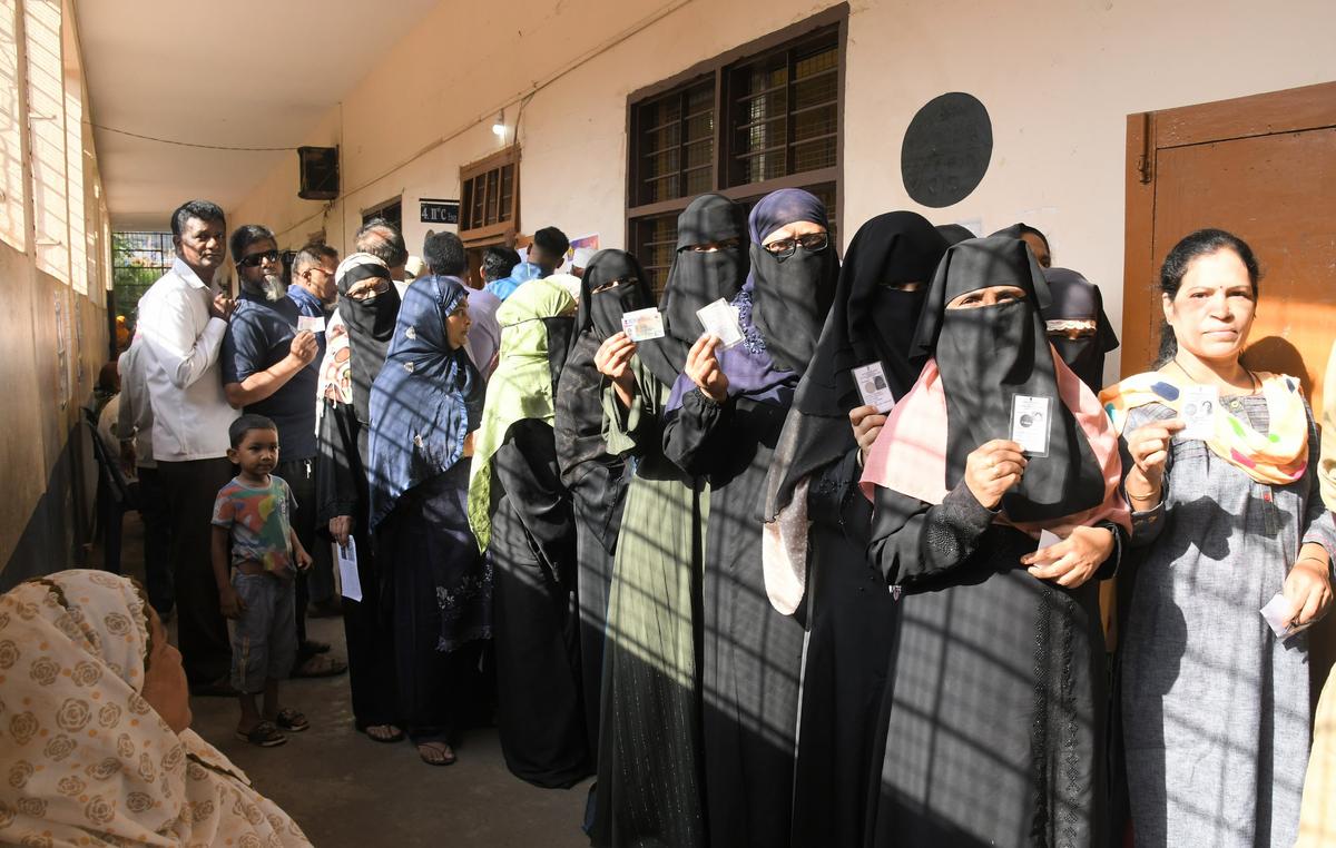 Women standing in queue at a polling station to vote in Belagavi Lok Sabha constituency.
