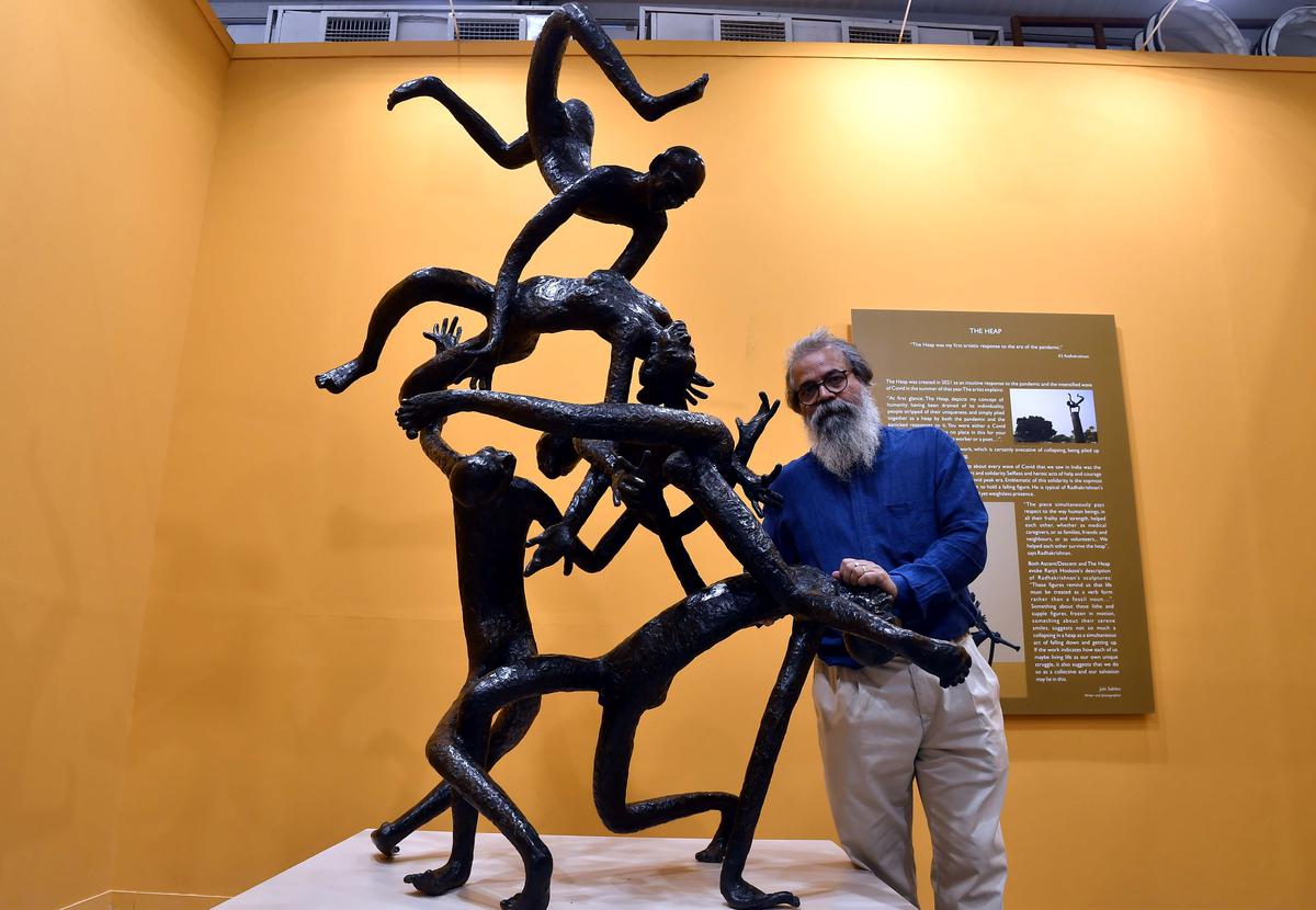 Sculptor K S Radhakrishnan poses with his work, on the first day of India Art Fair at NSIC in New Delhi 