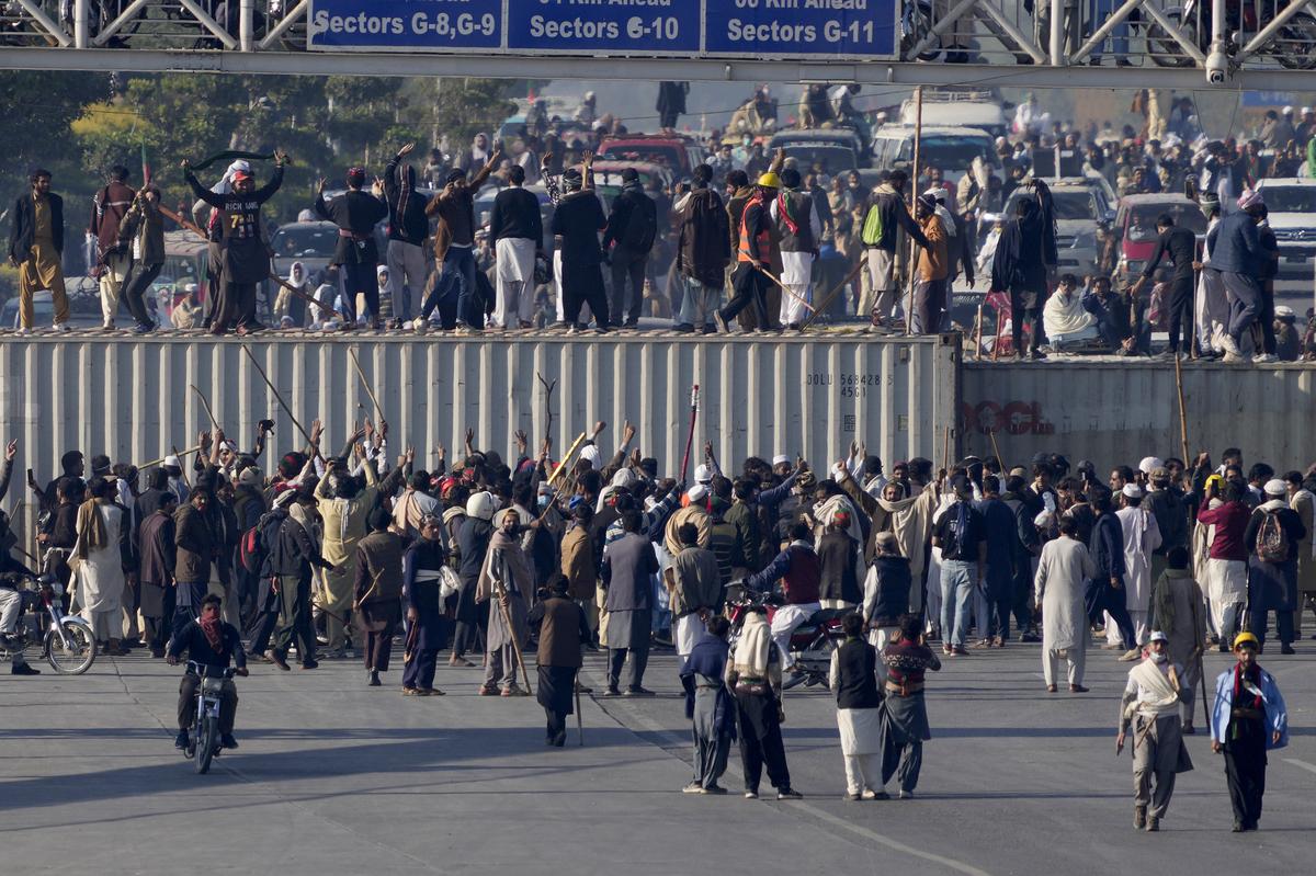 Supporters of imprisoned former premier Imran Khan’s Pakistan Tehreek-e-Insaf party, gather to remove shipping containers to clear way for their rally demanding Khan’s release, in Islamabad, Pakistan, on November 26, 2024.