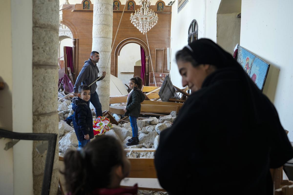 A man rings the bells next to a Christmas tree that has been decorated inside St. George Melkite Catholic Church in the town of Dardghaya in southern Lebanon, on December 22, 2024.