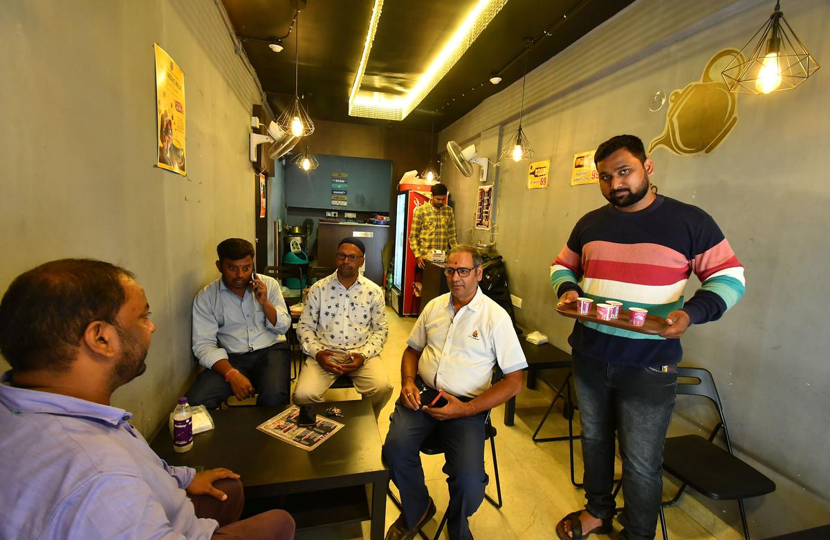 Shashikant serves tea to a group of people  