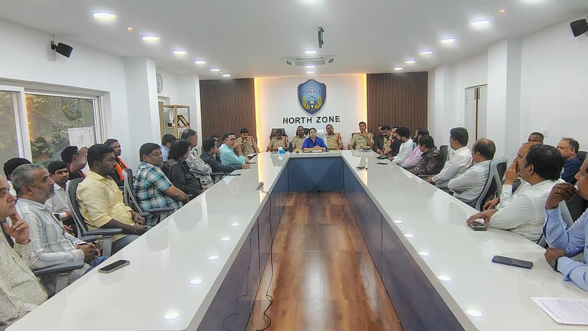 Police officials interact with jewellery and electronic store traders