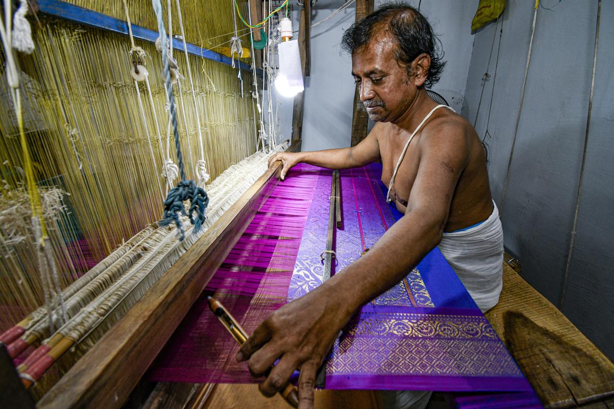 A silk weaver crafts a vibrant saree on a handloom in Thirubhuvanam. 