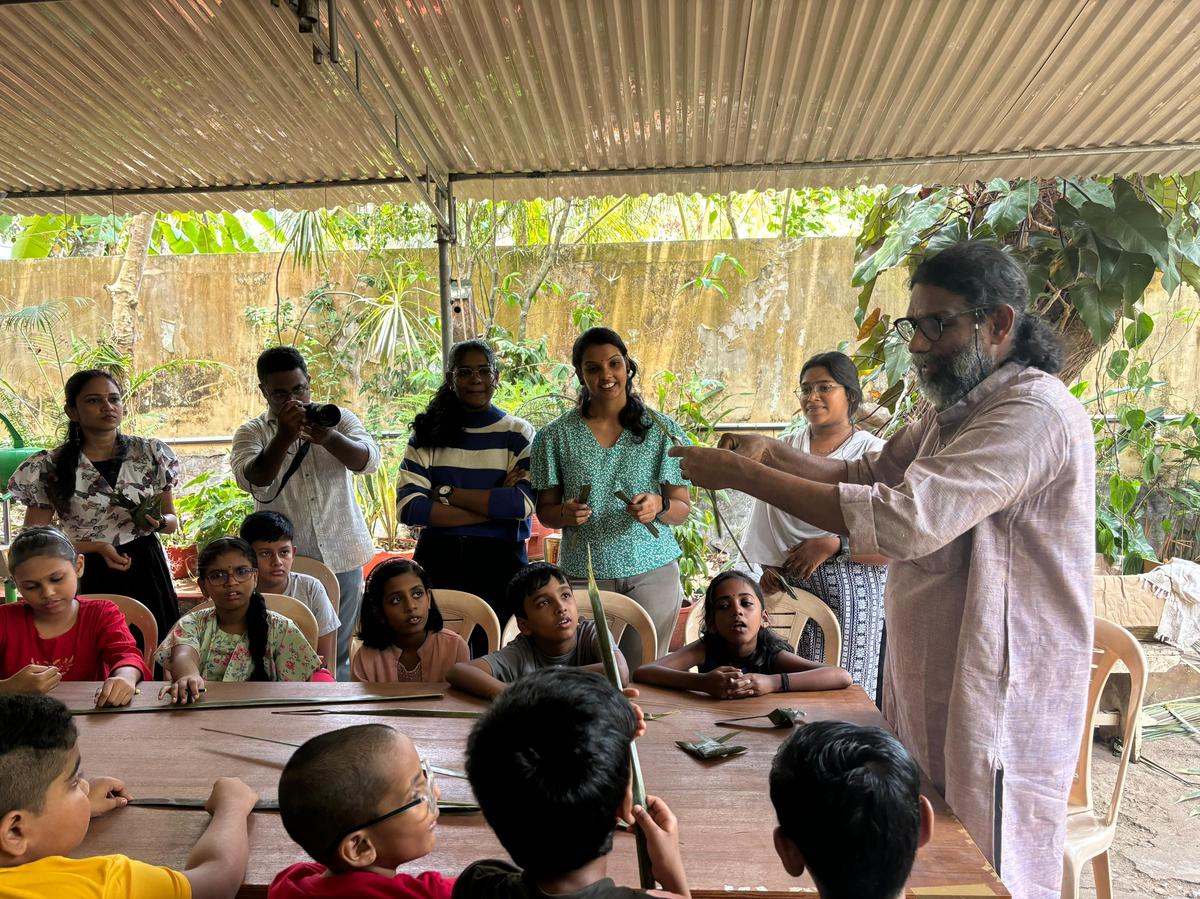 Artist and sculptor John Baby teaching children how to make toys from palm leaves at Thalir summer camp in Thiruvananthapuram.