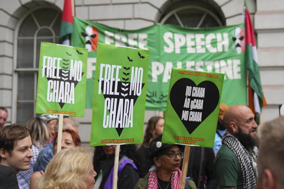 I sostenitori di Liam Óg Ó hAnnaidh, alias Mo Chara, un membro della band di lingua irlandese Kneecap, aspettano con cartelli, bandiere e striscioni il suo arrivo alla Westminster Magistrates Court di Londra, il 20 agosto 2025, dove è accusato di un reato di terrorismo