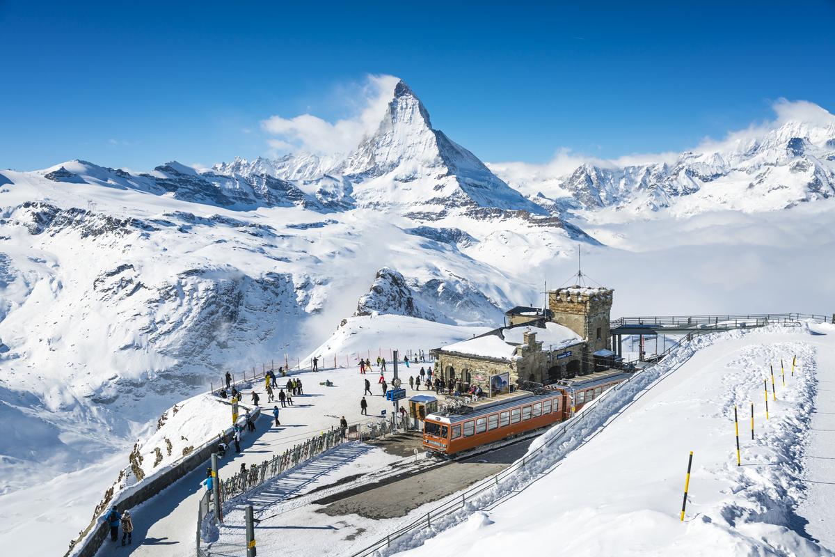 People at Gornergrat railway station with the Matterhorn peak in the background above Zermatt town in Mattertal, Valais canton, Switzerland. People at Gornergrat railway station with the Matterhorn peak in the background above Zermatt town in Mattertal, Valais canton, Switzerland.